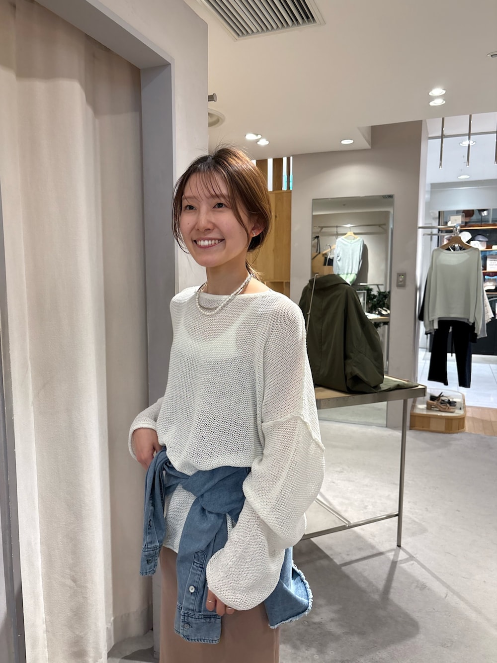 ブルー系のシャツ/ブラウス、ホワイト系のニット/セーター、ベージュ系のワンピースを着用したレディースの春コーディネートの2枚目の写真