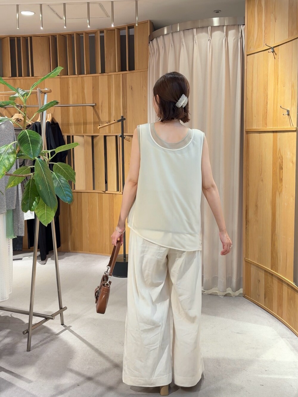ホワイト系のタンクトップ、ホワイト系のその他パンツ、ブラウン系のハンドバッグを着用したレディースの夏コーディネートの2枚目の写真