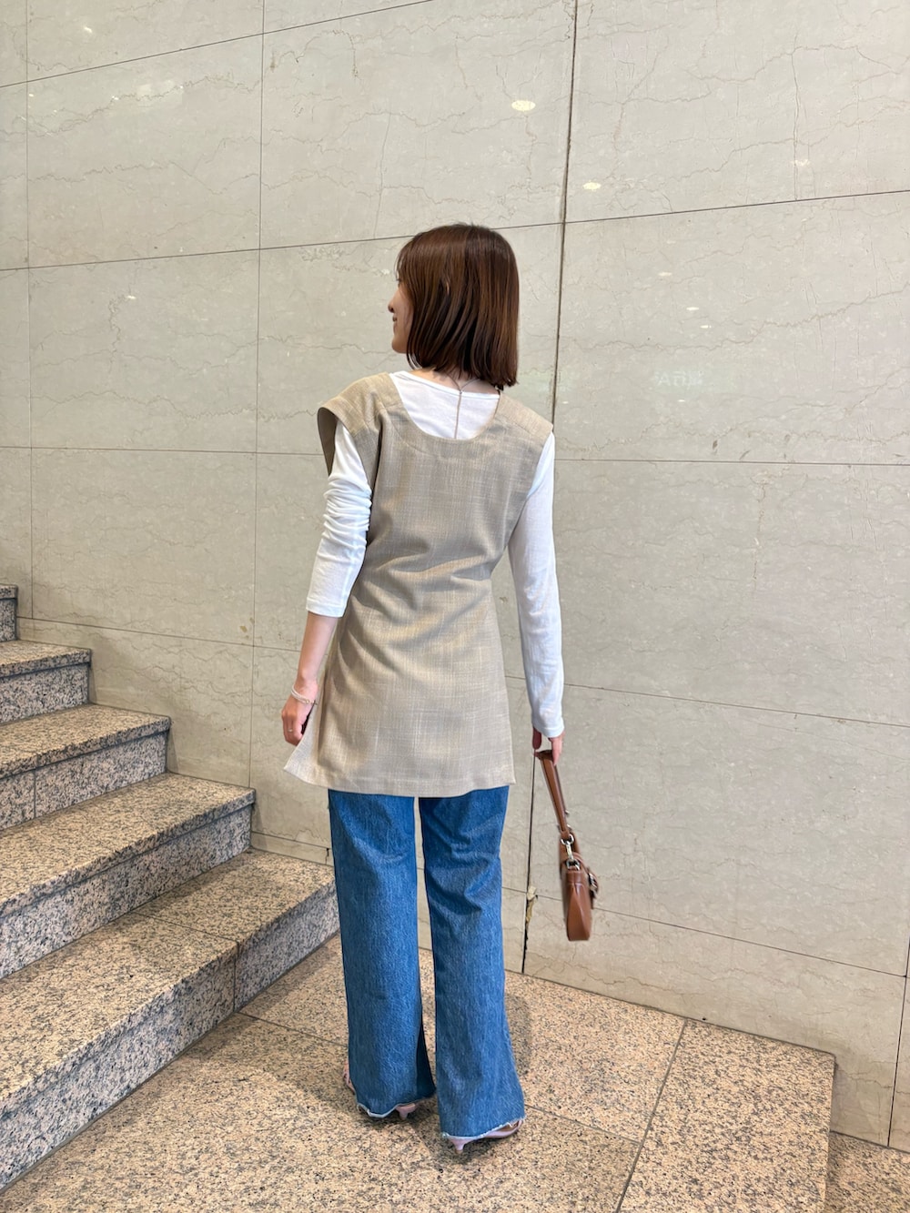 ベージュ系のシャツ/ブラウス、ホワイト系のTシャツ/カットソー、ブラウン系のハンドバッグを着用したレディースの夏コーディネートの4枚目の写真