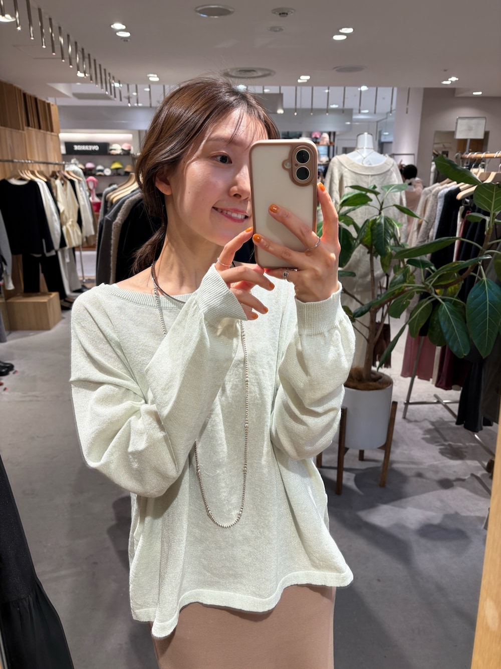 グリーン系のニット/セーター、ベージュ系のワンピース、イエロー系のその他シューズを着用したレディースの冬コーディネートの2枚目の写真