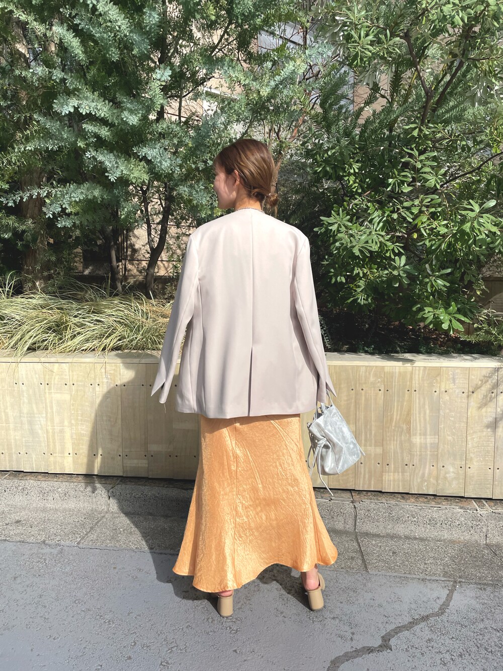 ホワイト系のTシャツ/カットソー、シルバー系のショルダーバッグ、オレンジ系のスカートを着用したレディースの冬コーディネートの3枚目の写真