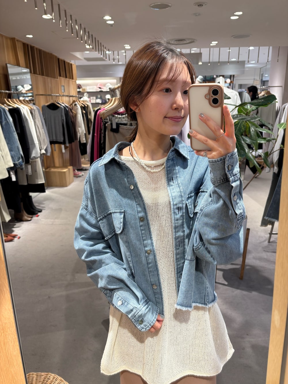 ブルー系のシャツ/ブラウス、ホワイト系のニット/セーター、ベージュ系のワンピースを着用したレディースの春コーディネートの5枚目の写真