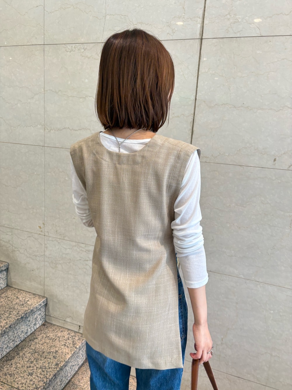 ベージュ系のシャツ/ブラウス、ホワイト系のTシャツ/カットソー、ブラウン系のハンドバッグを着用したレディースの夏コーディネートの5枚目の写真