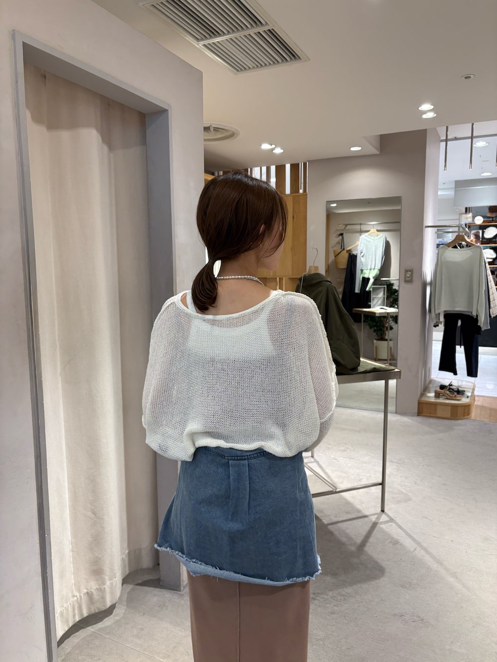 ブルー系のシャツ/ブラウス、ホワイト系のニット/セーター、ベージュ系のワンピースを着用したレディースの春コーディネートの3枚目の写真