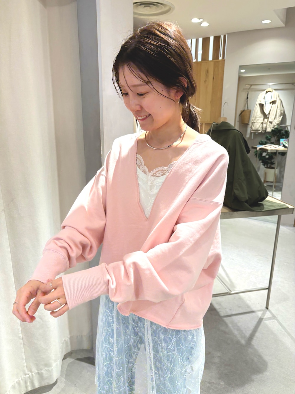 ピンク系のスウェット、ホワイト系のチュニック、ブルー系のデニムパンツを着用したレディースの春コーディネートの3枚目の写真