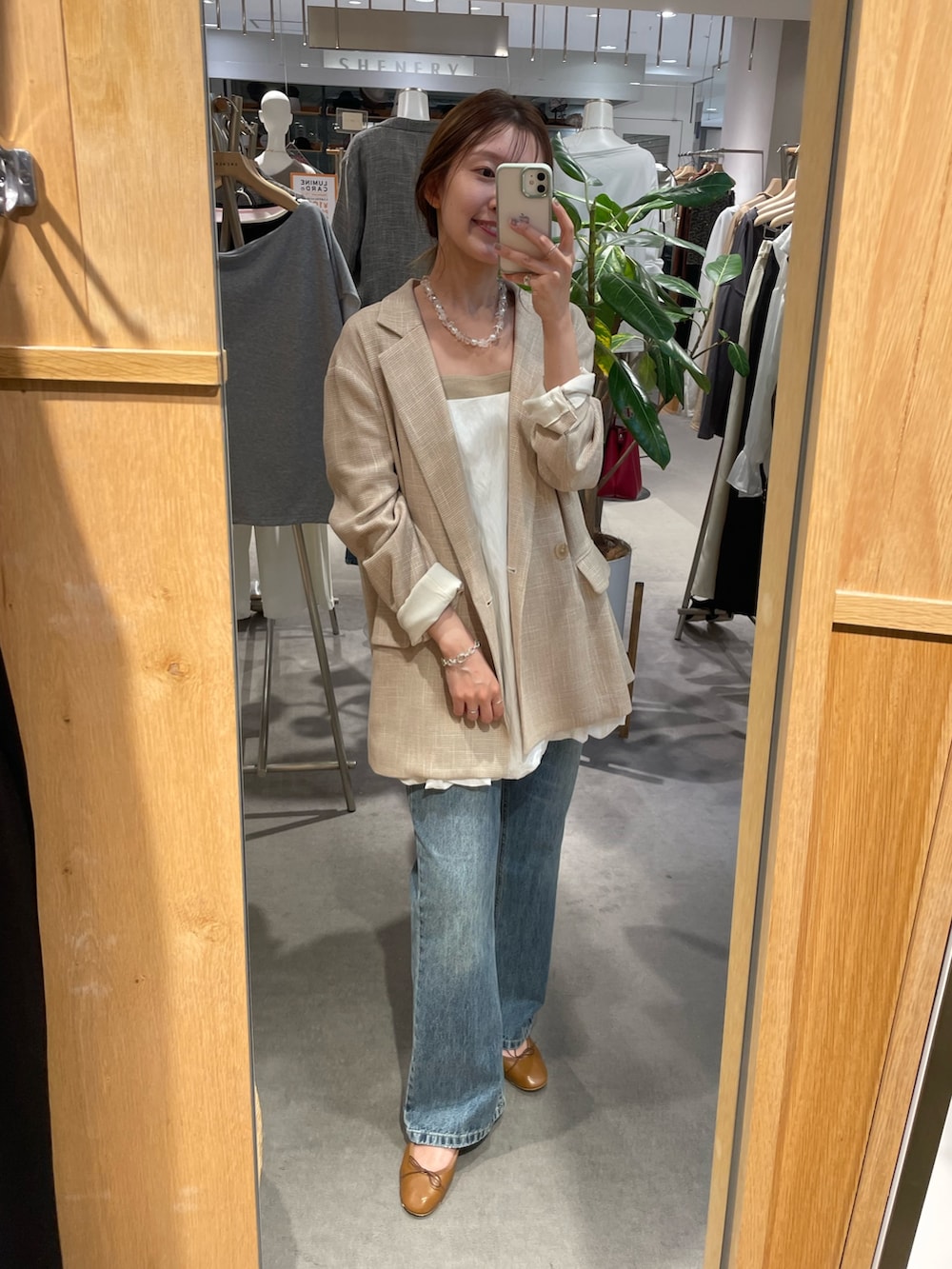 ベージュ系のテーラードジャケット、ホワイト系のシャツ/ブラウス、ベージュ系のキャミソールを着用したレディースの秋コーディネートの2枚目の写真