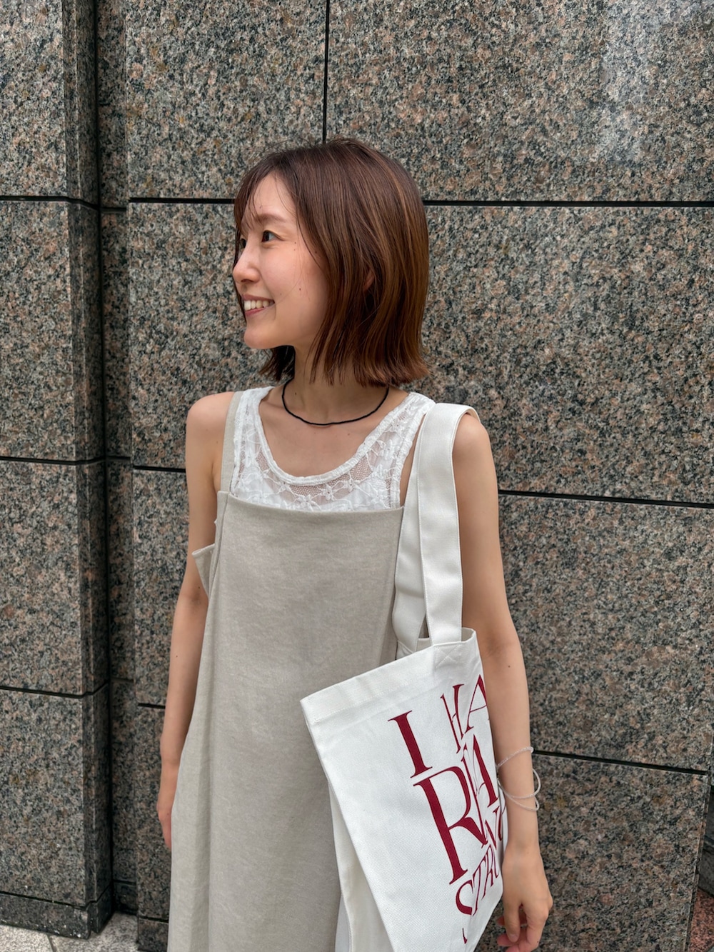 ベージュ系のワンピース、ホワイト系のTシャツ/カットソー、ホワイト系のトートバッグを着用したレディースの夏コーディネートの5枚目の写真