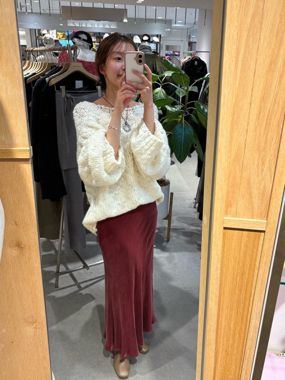 ホワイト系のニット/セーター、シルバー系のトートバッグ、レッド系のスカートを着用したレディースの冬コーディネートの3枚目の写真