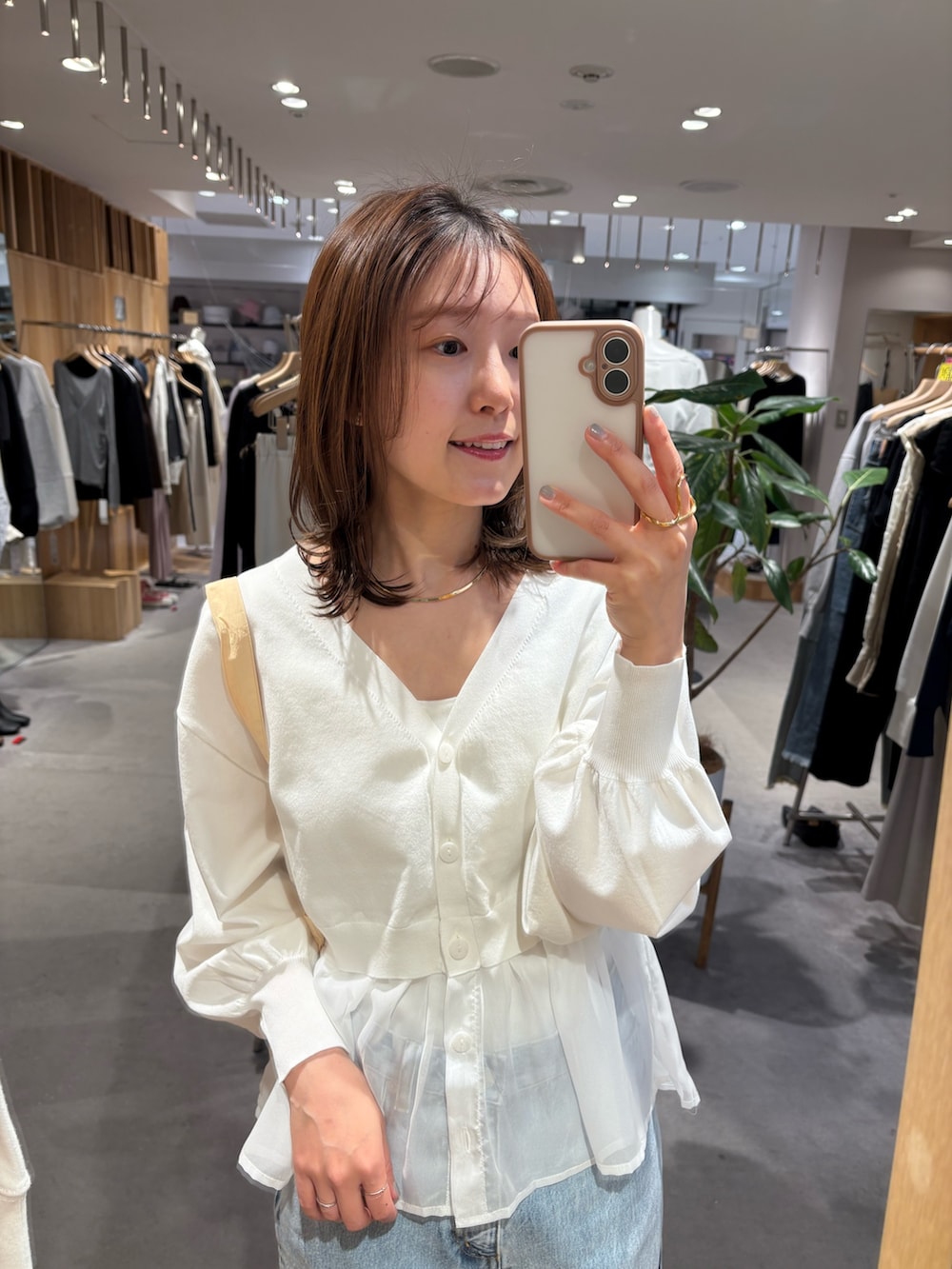 ホワイト系のカーディガン/ボレロ、ブルー系のデニムパンツ、イエロー系のトートバッグを着用したレディースの春コーディネートの2枚目の写真