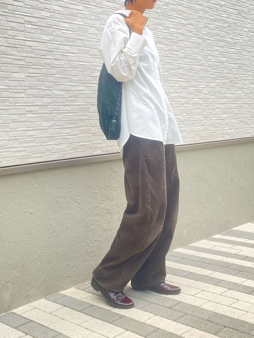 ブラウン系のパンツ、ホワイト系のシャツ/ブラウス、ブラウン系のローファーを着用したレディースの秋コーディネートの2枚目の写真