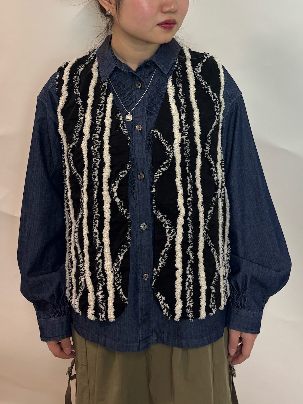 ブルー系のシャツ/ブラウス、ブラック系のブルゾン、グリーン系のスカートを着用したレディースの冬コーディネートの2枚目の写真