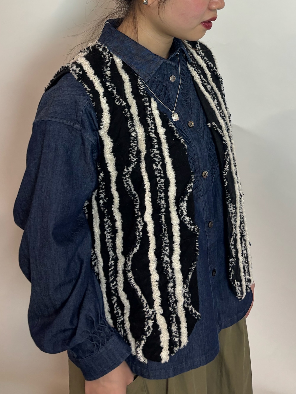 ブルー系のシャツ/ブラウス、ブラック系のブルゾン、グリーン系のスカートを着用したレディースの冬コーディネートの3枚目の写真