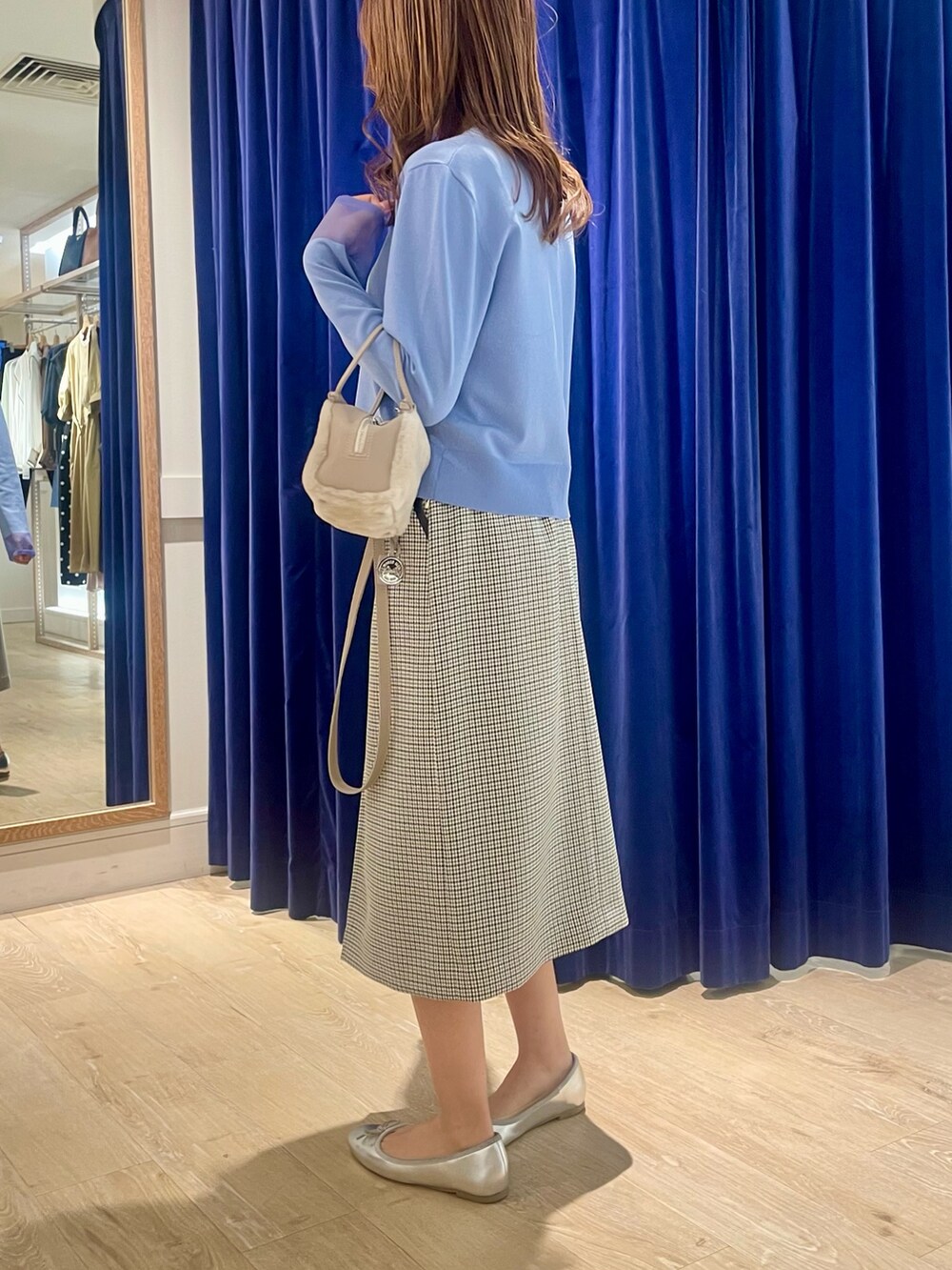 ブルー系のカーディガン/ボレロ、ベージュ系のショルダーバッグ、ブラック系のスカートを着用したレディースの秋コーディネートの3枚目の写真