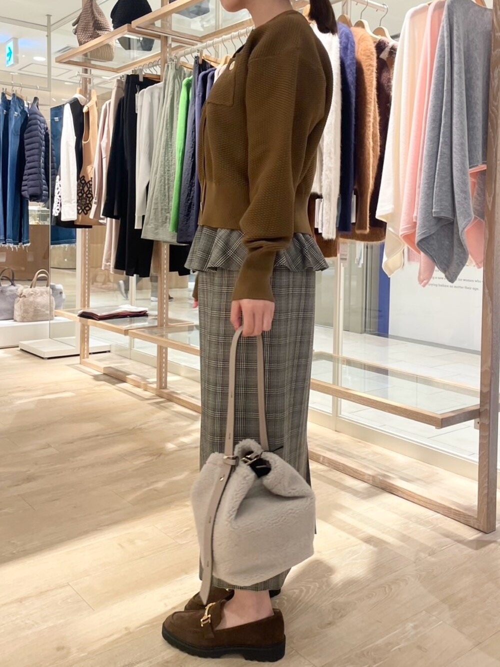 ブラウン系のスカート、イエロー系のカーディガン/ボレロ、ベージュ系のショルダーバッグを着用したレディースの秋コーディネートの4枚目の写真