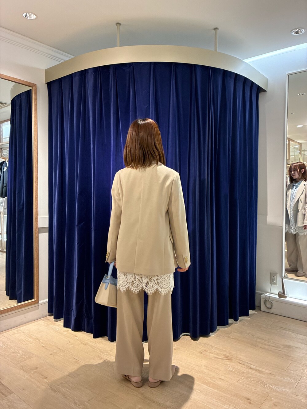 ベージュ系のその他パンツ、ベージュ系のテーラードジャケット、ホワイト系のキャミソールを着用したレディースの春コーディネートの4枚目の写真