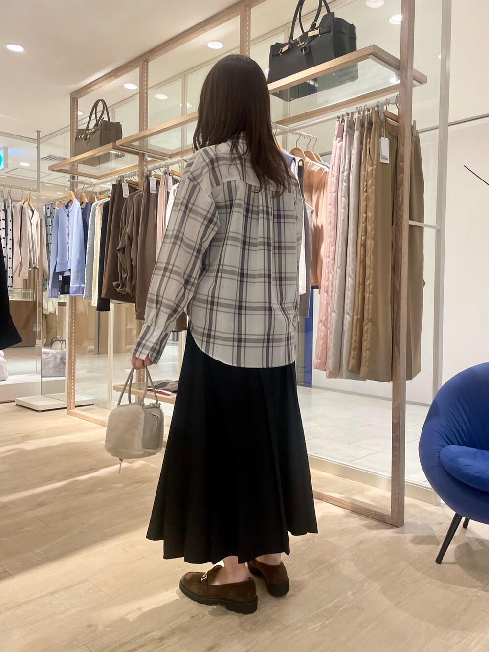 ブラック系のスカート、ブラウン系のローファー、ホワイト系のシャツ/ブラウスを着用したレディースの秋コーディネートの4枚目の写真