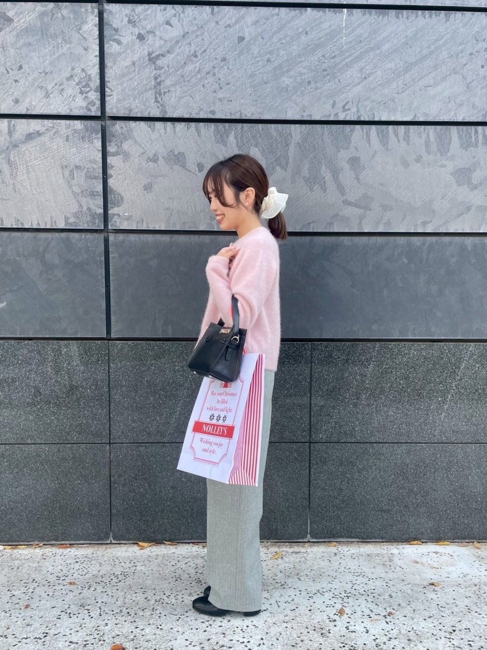 ピンク系のカーディガン/ボレロ、グレー系のその他パンツ、ブラック系のショルダーバッグを着用したレディースの秋コーディネートの2枚目の写真