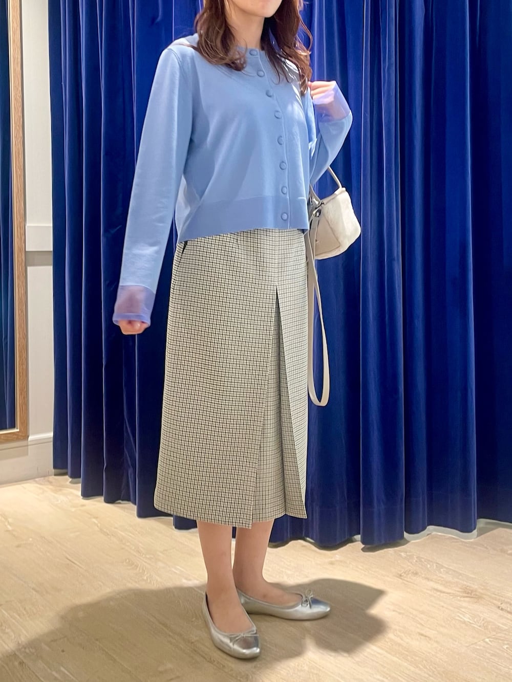 ブルー系のカーディガン/ボレロ、ベージュ系のショルダーバッグ、ブラック系のスカートを着用したレディースの秋コーディネートの7枚目の写真