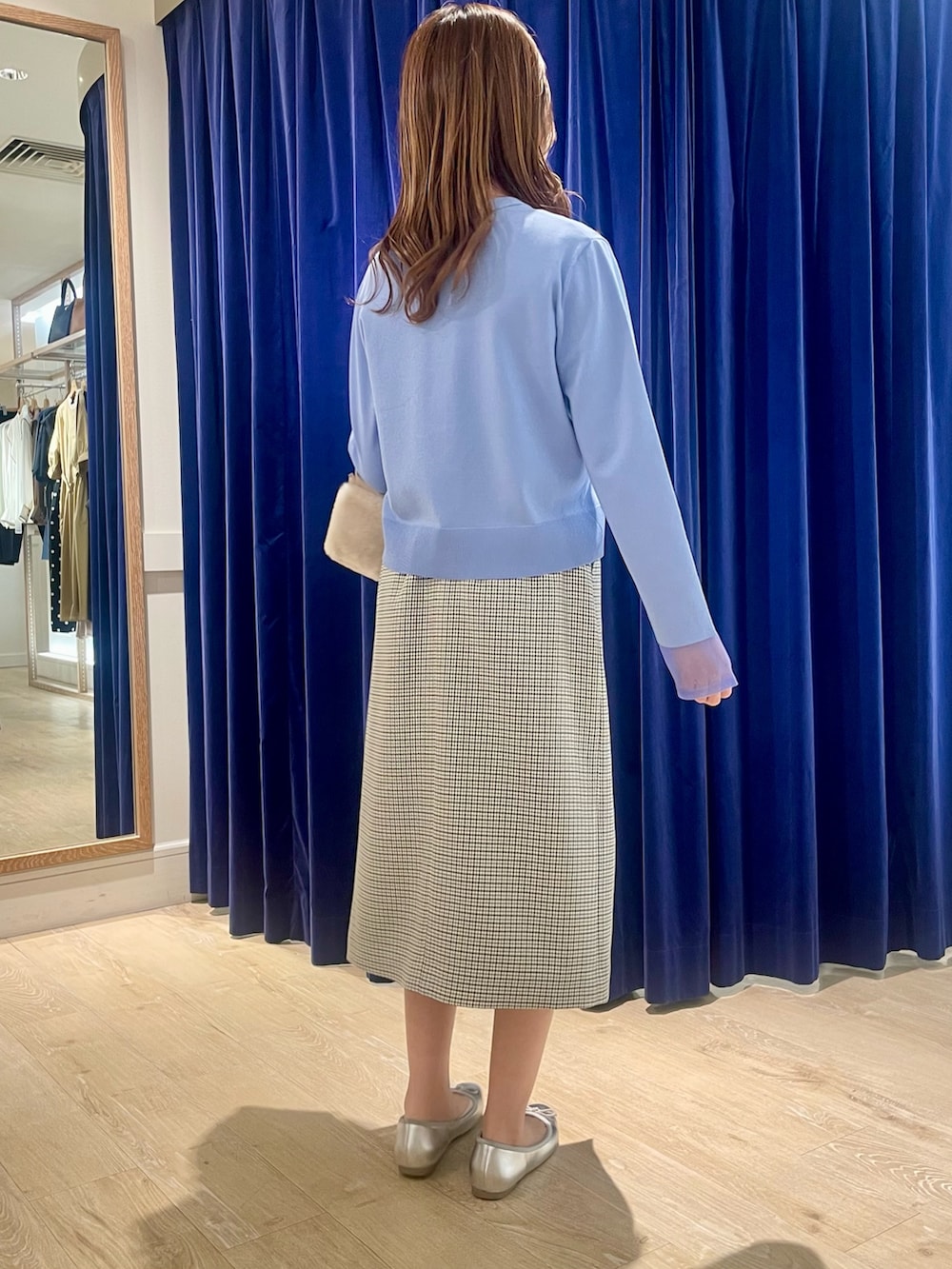 ブルー系のカーディガン/ボレロ、ベージュ系のショルダーバッグ、ブラック系のスカートを着用したレディースの秋コーディネートの5枚目の写真