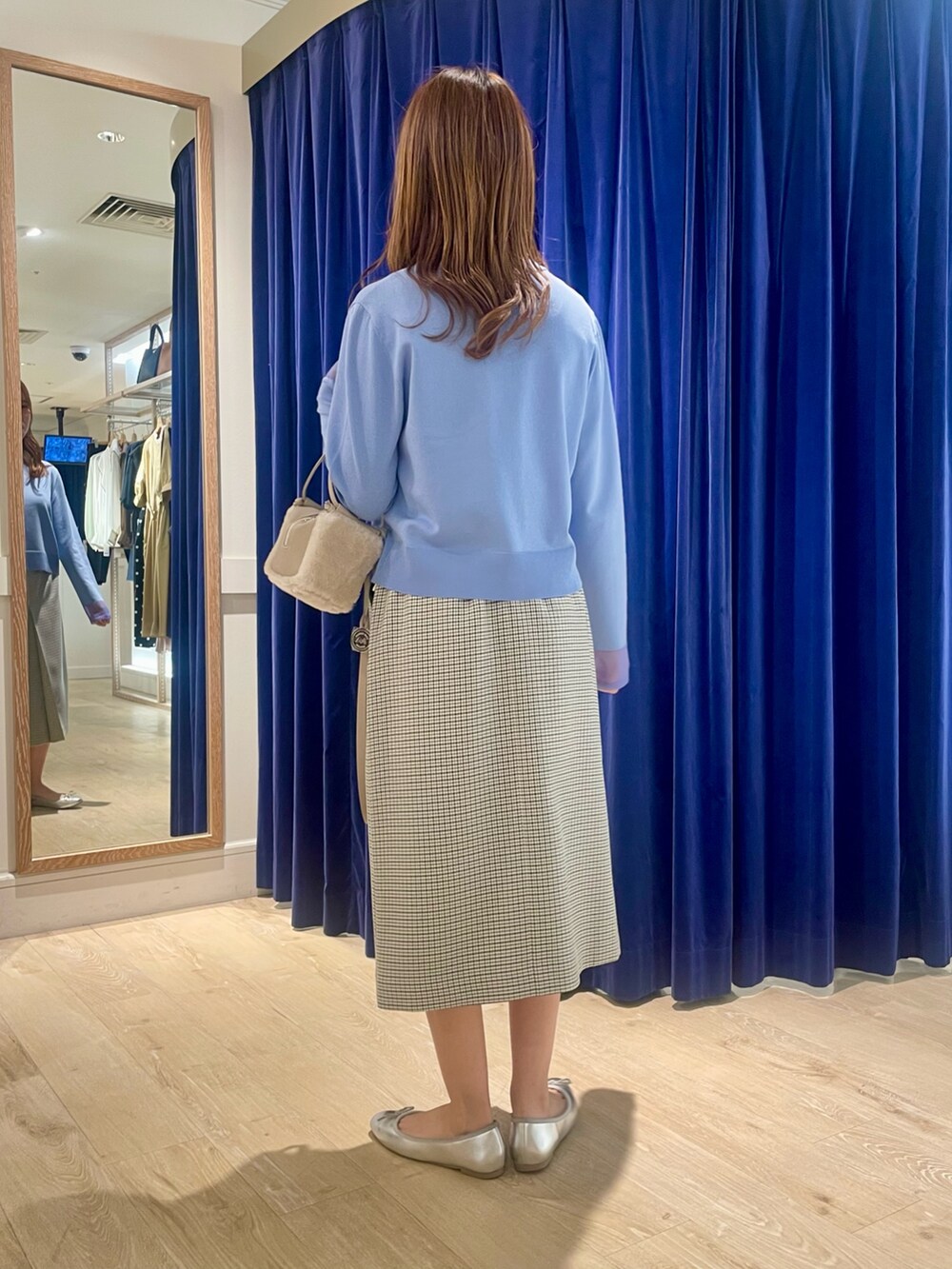 ブルー系のカーディガン/ボレロ、ベージュ系のショルダーバッグ、ブラック系のスカートを着用したレディースの秋コーディネートの4枚目の写真