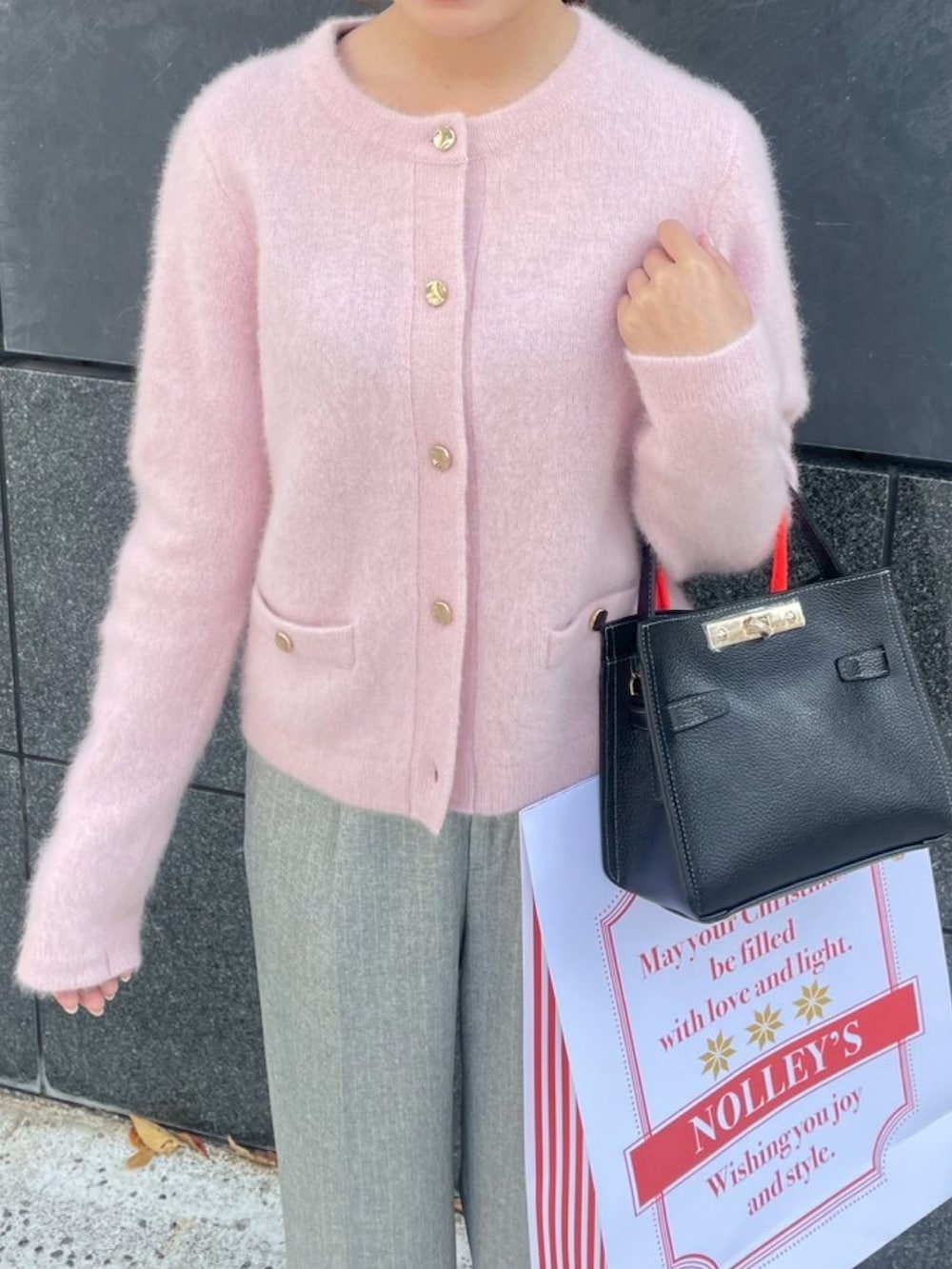 ピンク系のカーディガン/ボレロ、グレー系のその他パンツ、ブラック系のショルダーバッグを着用したレディースの秋コーディネートの6枚目の写真