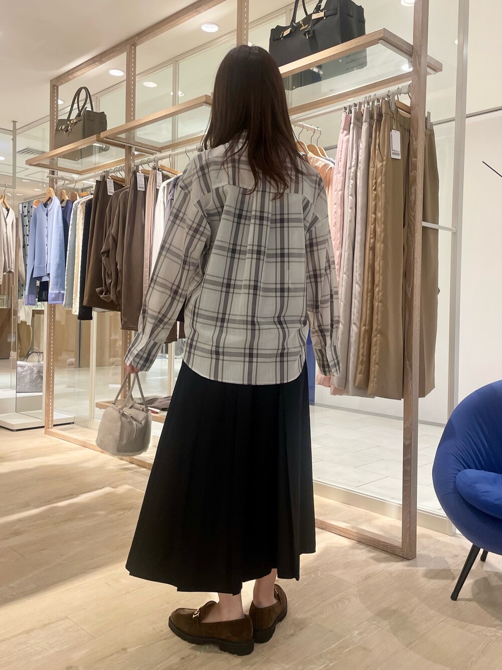 ブラック系のスカート、ブラウン系のローファー、ホワイト系のシャツ/ブラウスを着用したレディースの秋コーディネートの5枚目の写真