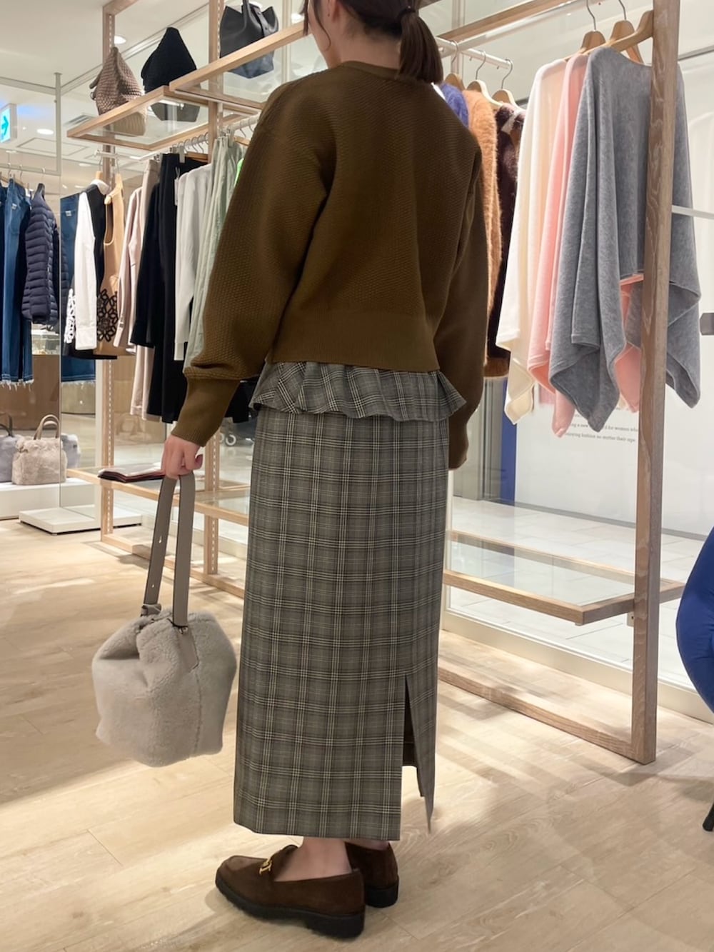 ブラウン系のスカート、イエロー系のカーディガン/ボレロ、ベージュ系のショルダーバッグを着用したレディースの秋コーディネートの3枚目の写真