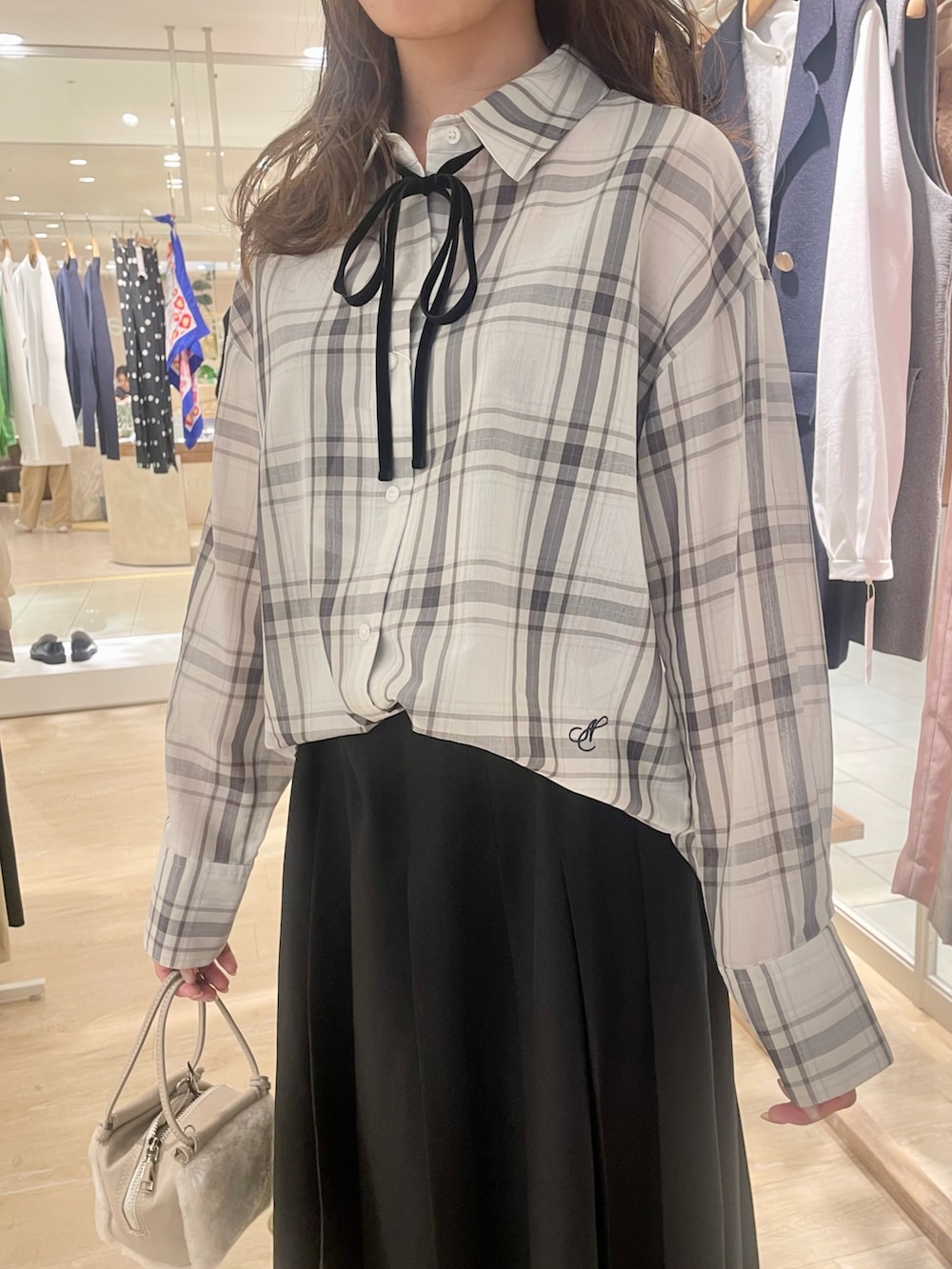 ブラック系のスカート、ブラウン系のローファー、ホワイト系のシャツ/ブラウスを着用したレディースの秋コーディネートの8枚目の写真