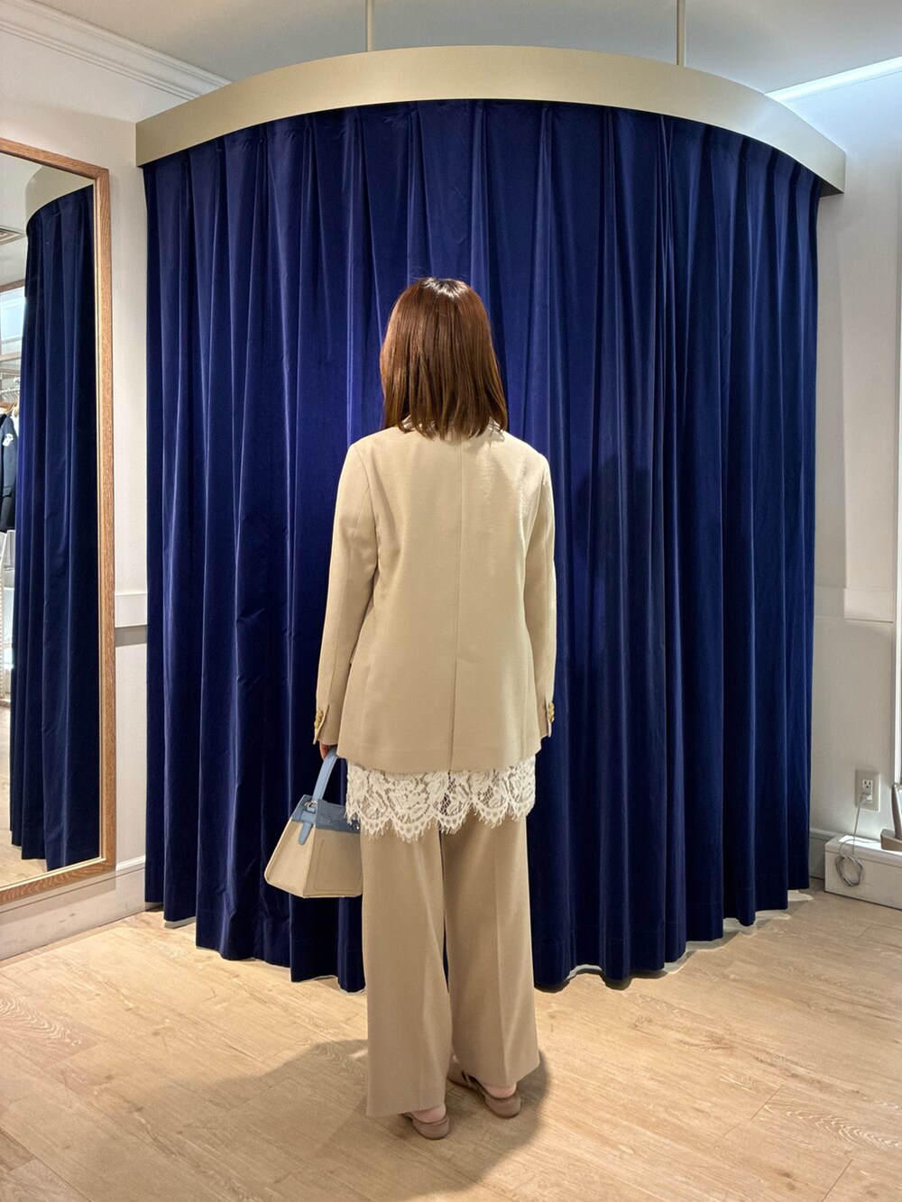 ベージュ系のその他パンツ、ベージュ系のテーラードジャケット、ホワイト系のキャミソールを着用したレディースの春コーディネートの3枚目の写真