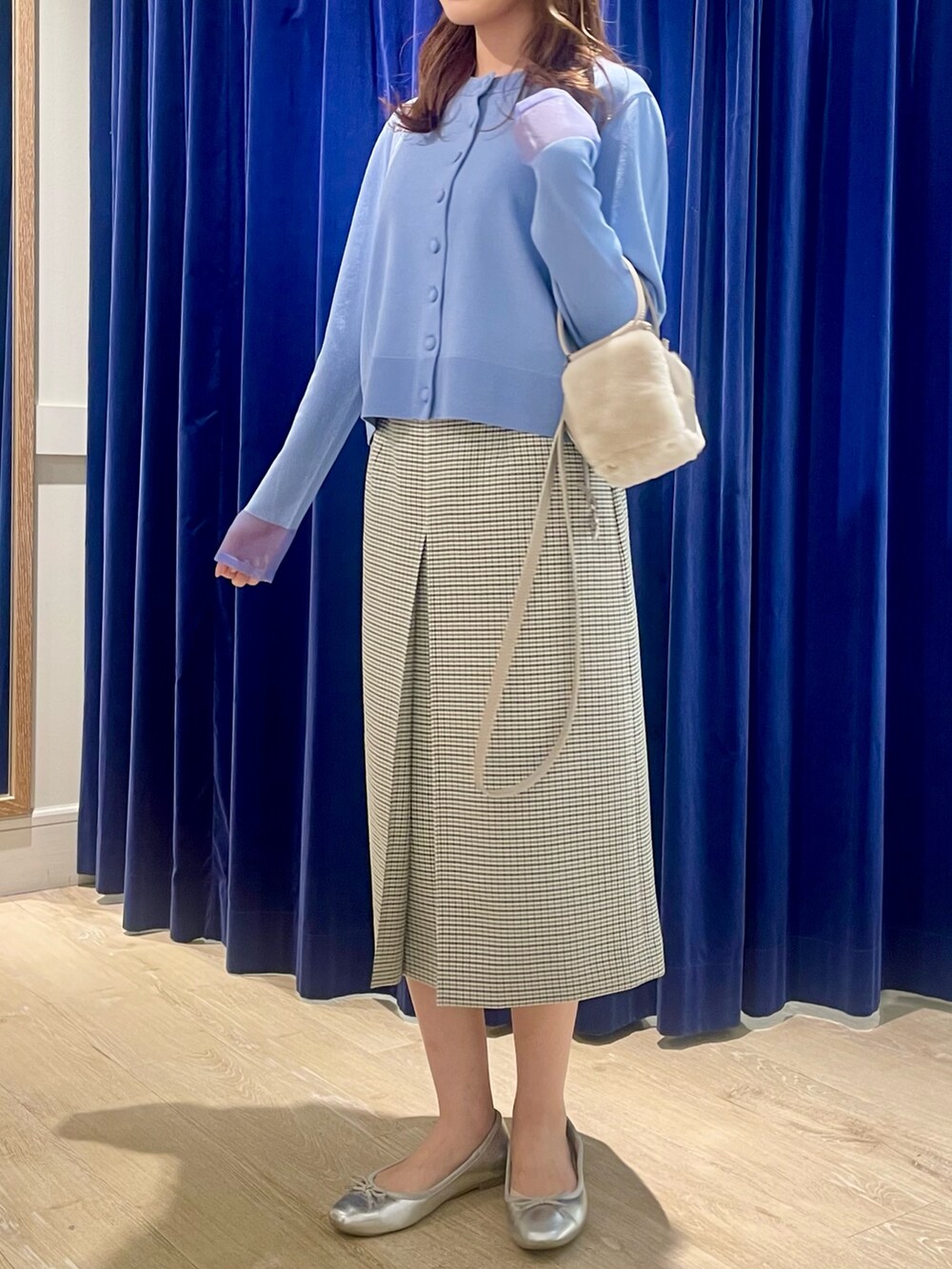 ブルー系のカーディガン/ボレロ、ベージュ系のショルダーバッグ、ブラック系のスカートを着用したレディースの秋コーディネートの2枚目の写真