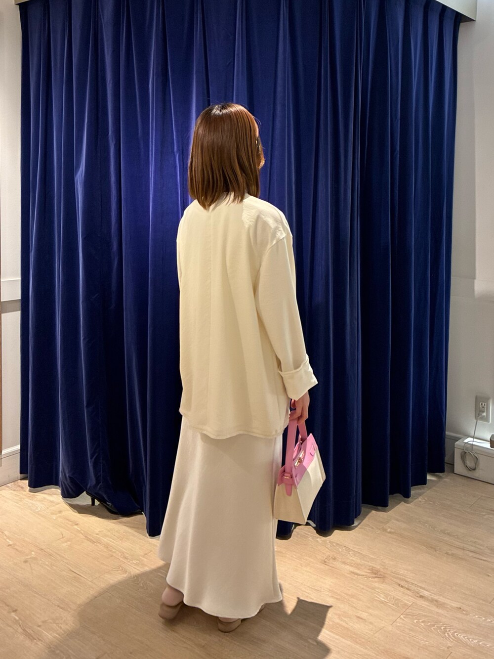 ホワイト系のスカート、ピンク系のショルダーバッグ、ホワイト系のノーカラージャケットを着用したレディースの春コーディネートの4枚目の写真