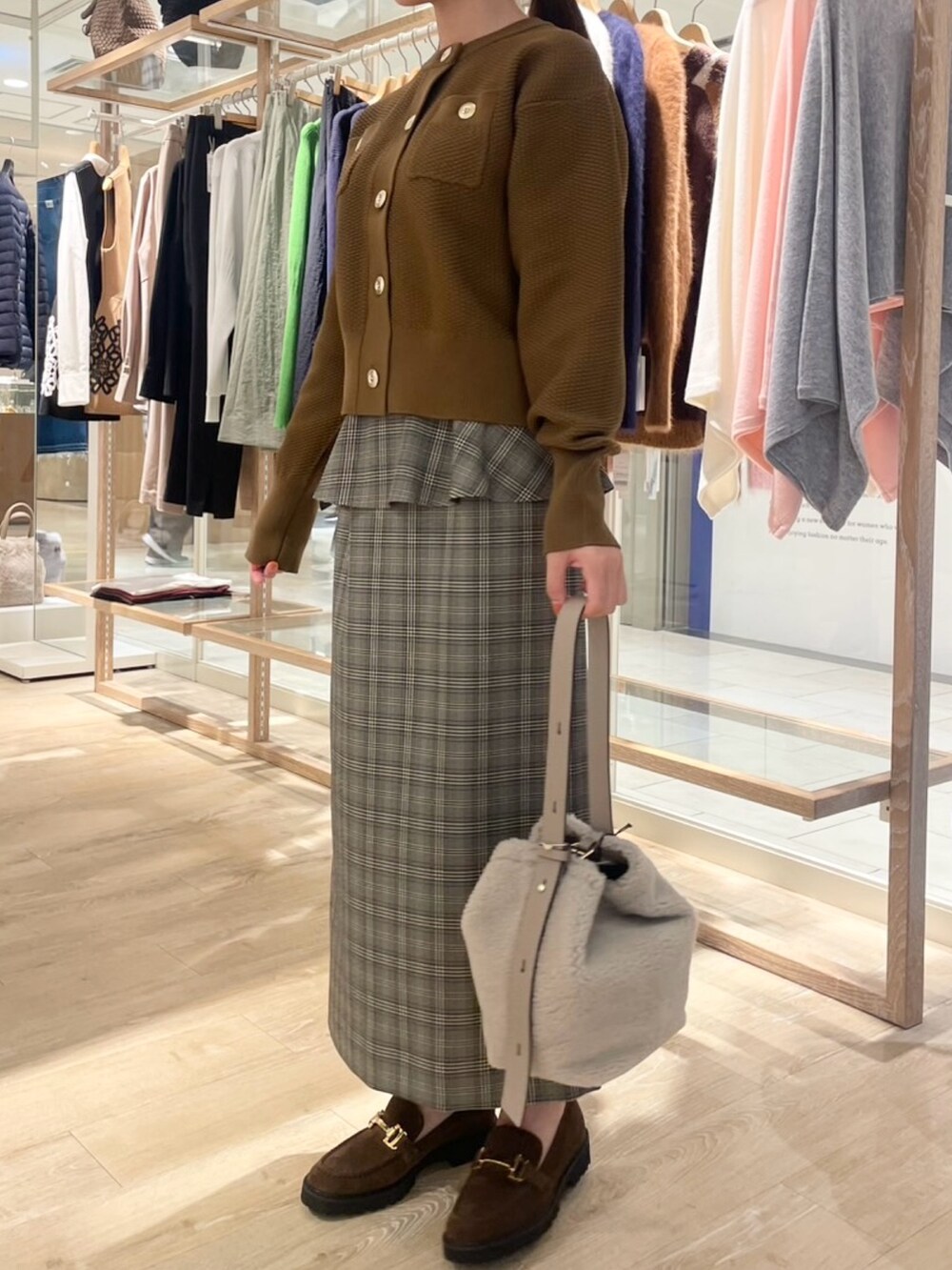 ブラウン系のスカート、イエロー系のカーディガン/ボレロ、ベージュ系のショルダーバッグを着用したレディースの秋コーディネートの2枚目の写真