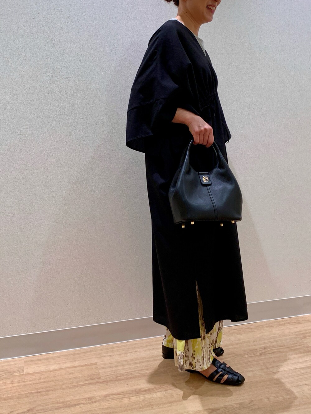 ブラック系のサンダル、ブラック系のショルダーバッグを着用したレディースの春コーディネートの2枚目の写真