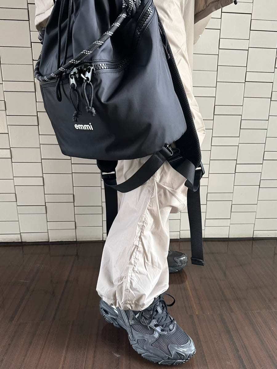 ブラック系のバックパック/リュック、ブラウン系のニット/セーター、ブラック系のスニーカーを着用したレディースの秋コーディネートの5枚目の写真