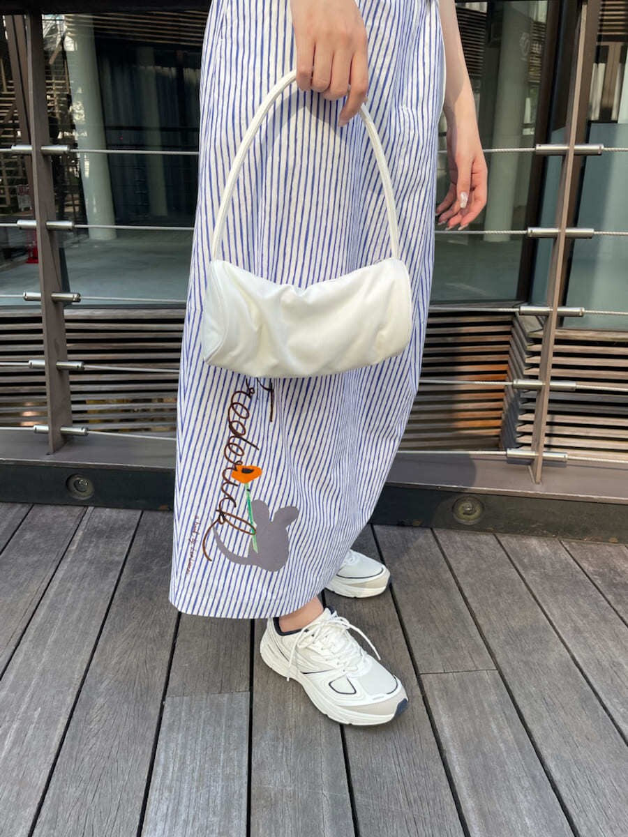 ホワイト系のハンドバッグ、その他のスカート、ホワイト系のニット/セーターを着用したレディースの夏コーディネートの7枚目の写真