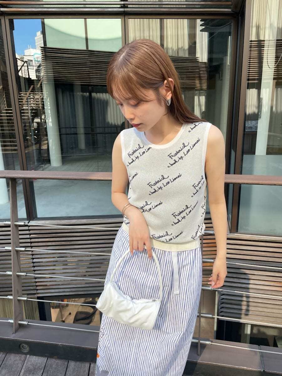 ホワイト系のハンドバッグ、その他のスカート、ホワイト系のニット/セーターを着用したレディースの夏コーディネートの5枚目の写真