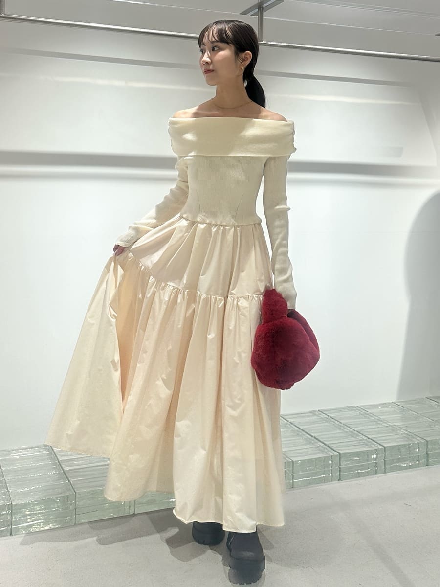 ブラウン系のチェスターコート、ホワイト系のワンピース、レッド系のハンドバッグを着用したレディースの秋コーディネートの4枚目の写真