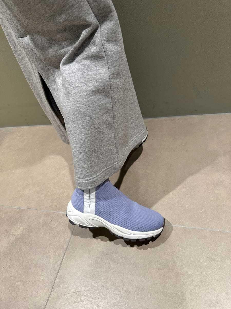 グレー系のワンピース、ブルー系のブーツ、ブルー系のハンドバッグを着用したレディースの秋コーディネートの6枚目の写真