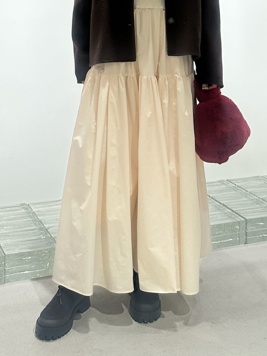 ブラウン系のチェスターコート、ホワイト系のワンピース、レッド系のハンドバッグを着用したレディースの秋コーディネートの7枚目の写真