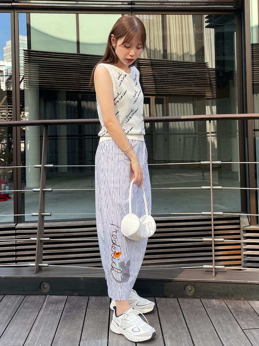 ホワイト系のハンドバッグ、その他のスカート、ホワイト系のニット/セーターを着用したレディースの夏コーディネートの2枚目の写真