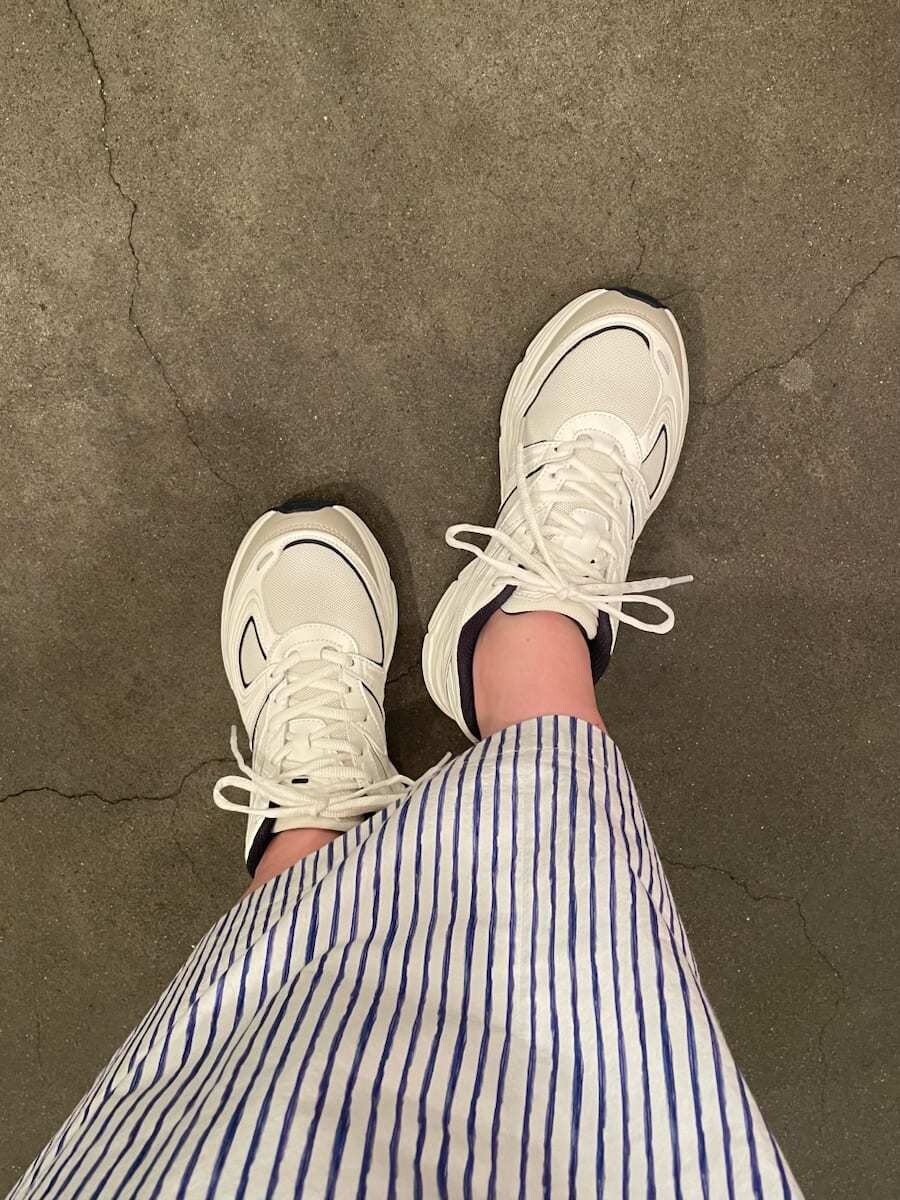 ホワイト系のハンドバッグ、その他のスカート、ホワイト系のニット/セーターを着用したレディースの夏コーディネートの8枚目の写真