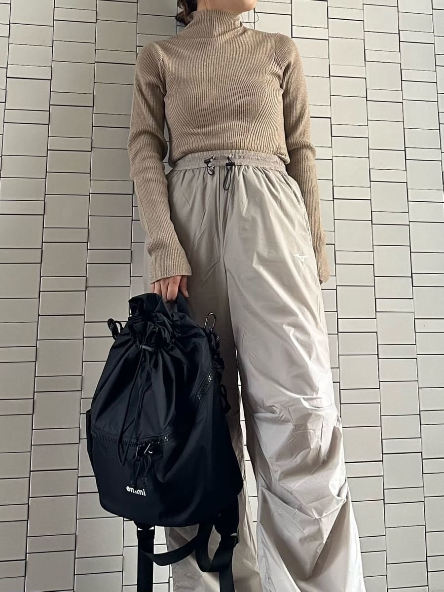 ブラック系のバックパック/リュック、ブラウン系のニット/セーター、ブラック系のスニーカーを着用したレディースの秋コーディネートの3枚目の写真