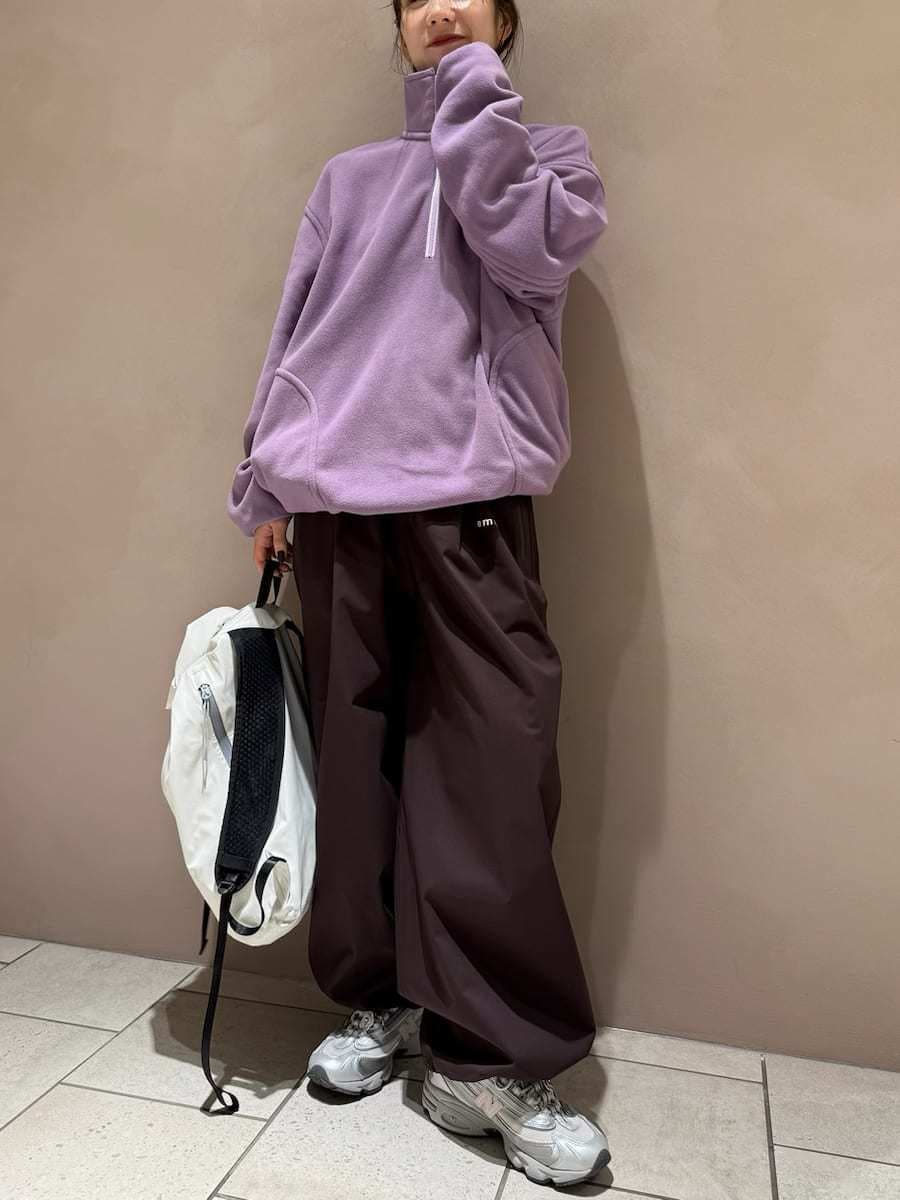 パープル系のスウェット、ブラウン系のその他パンツ、ベージュ系のバックパック/リュックを着用したレディースの秋コーディネートの3枚目の写真