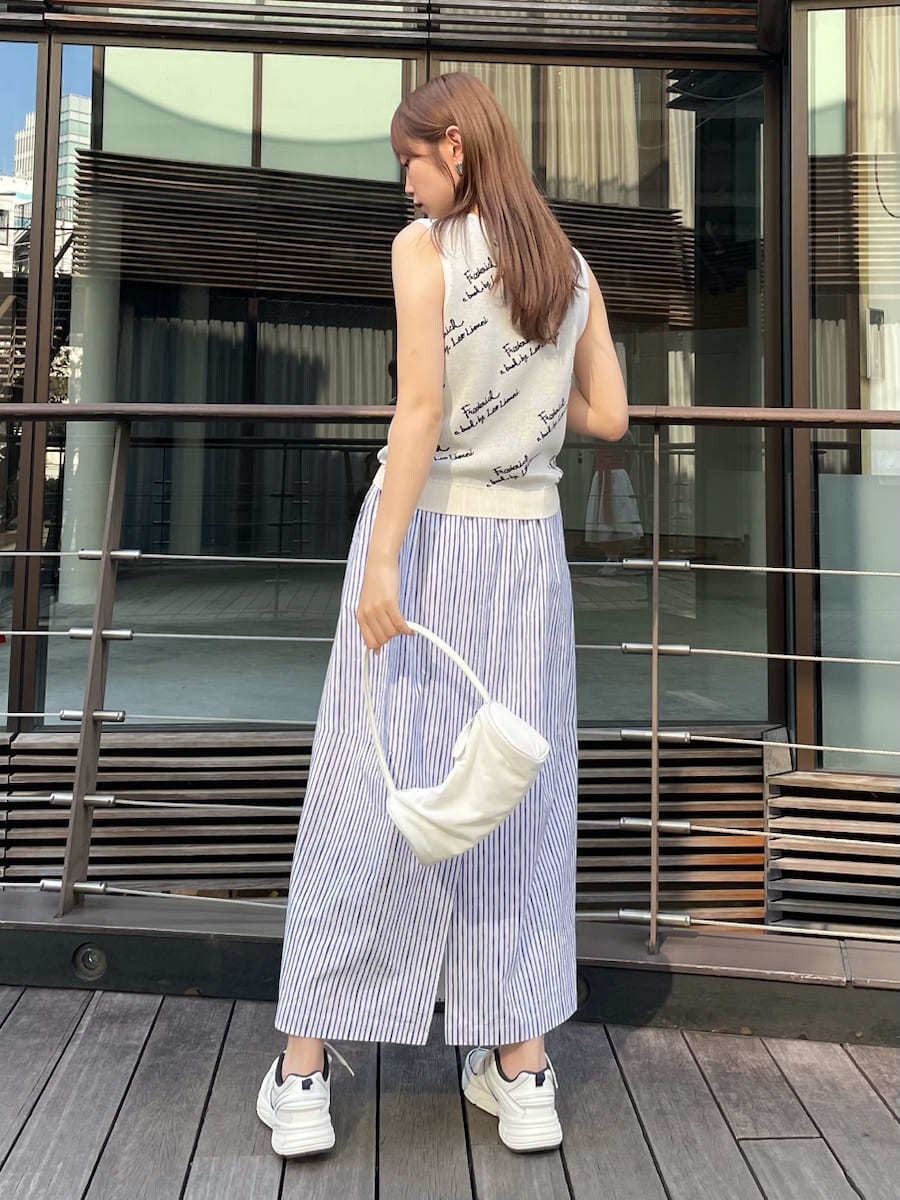 ホワイト系のハンドバッグ、その他のスカート、ホワイト系のニット/セーターを着用したレディースの夏コーディネートの3枚目の写真