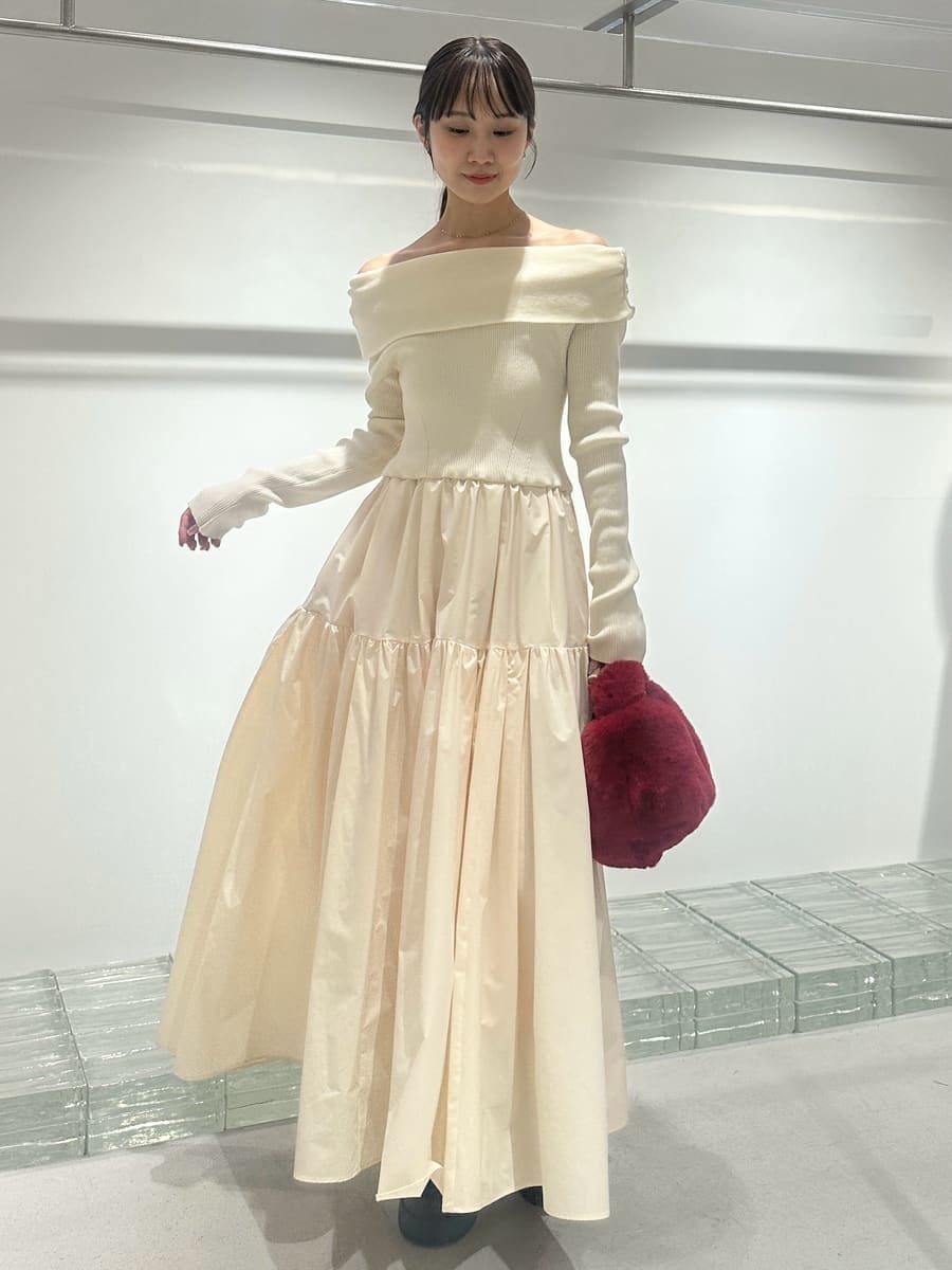 ブラウン系のチェスターコート、ホワイト系のワンピース、レッド系のハンドバッグを着用したレディースの秋コーディネートの6枚目の写真