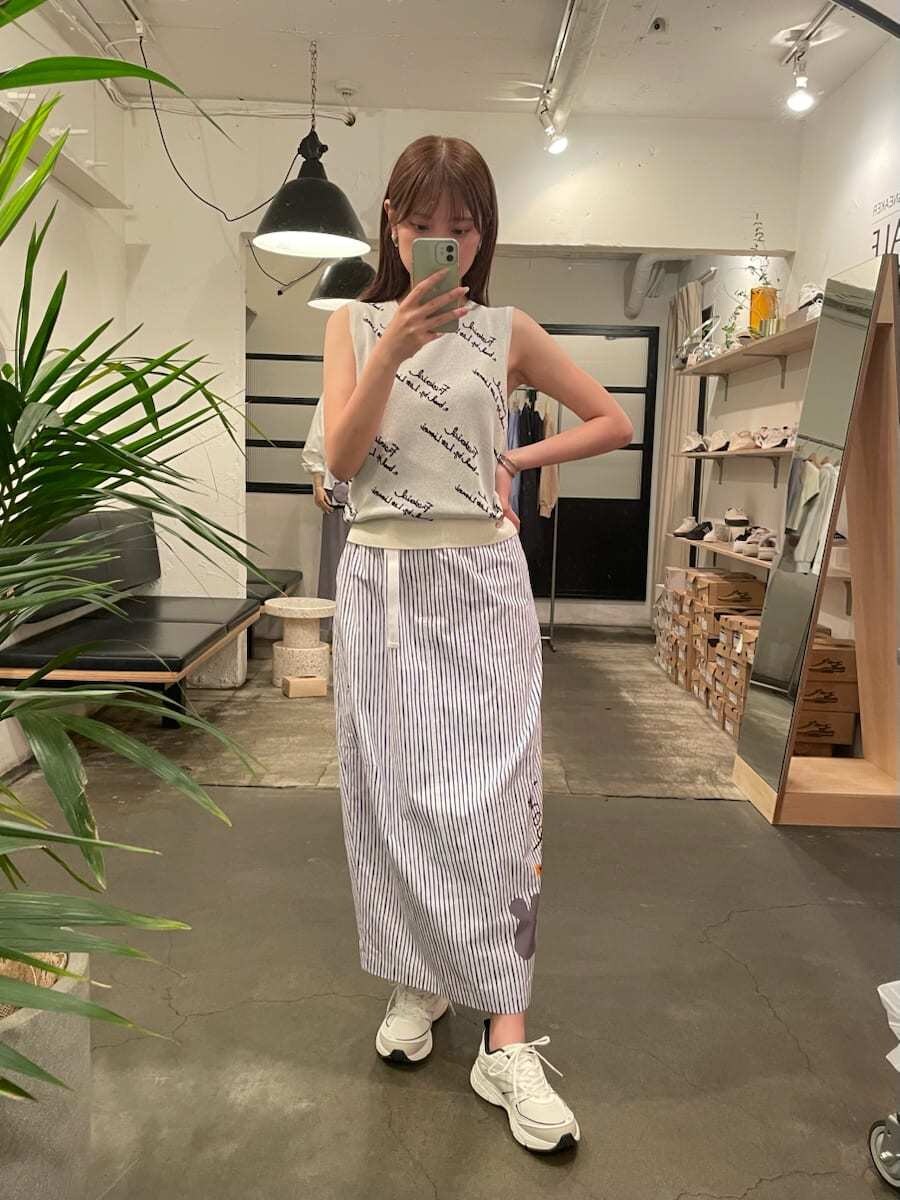 ホワイト系のハンドバッグ、その他のスカート、ホワイト系のニット/セーターを着用したレディースの夏コーディネートの6枚目の写真