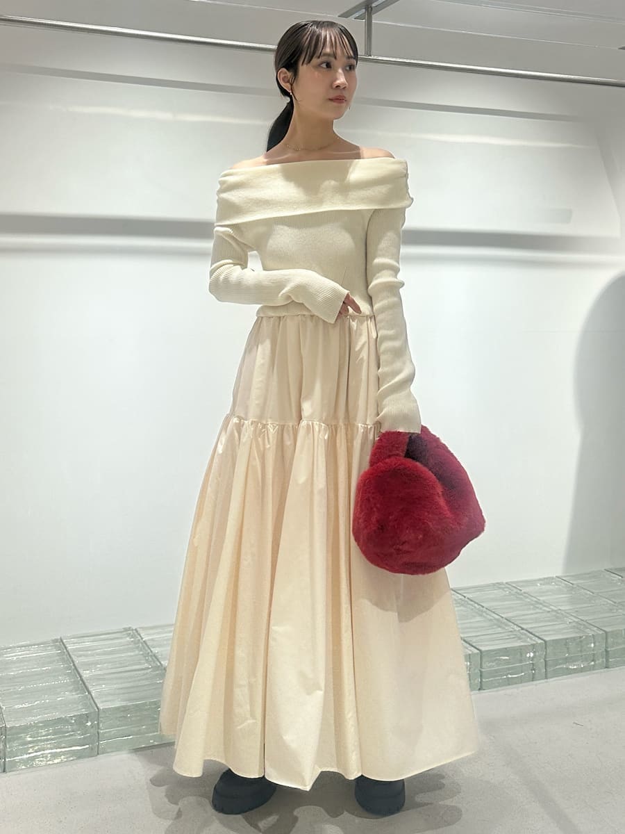 ブラウン系のチェスターコート、ホワイト系のワンピース、レッド系のハンドバッグを着用したレディースの秋コーディネートの3枚目の写真