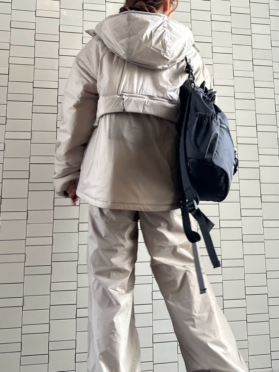 ブラック系のバックパック/リュック、ブラウン系のニット/セーター、ブラック系のスニーカーを着用したレディースの秋コーディネートの4枚目の写真