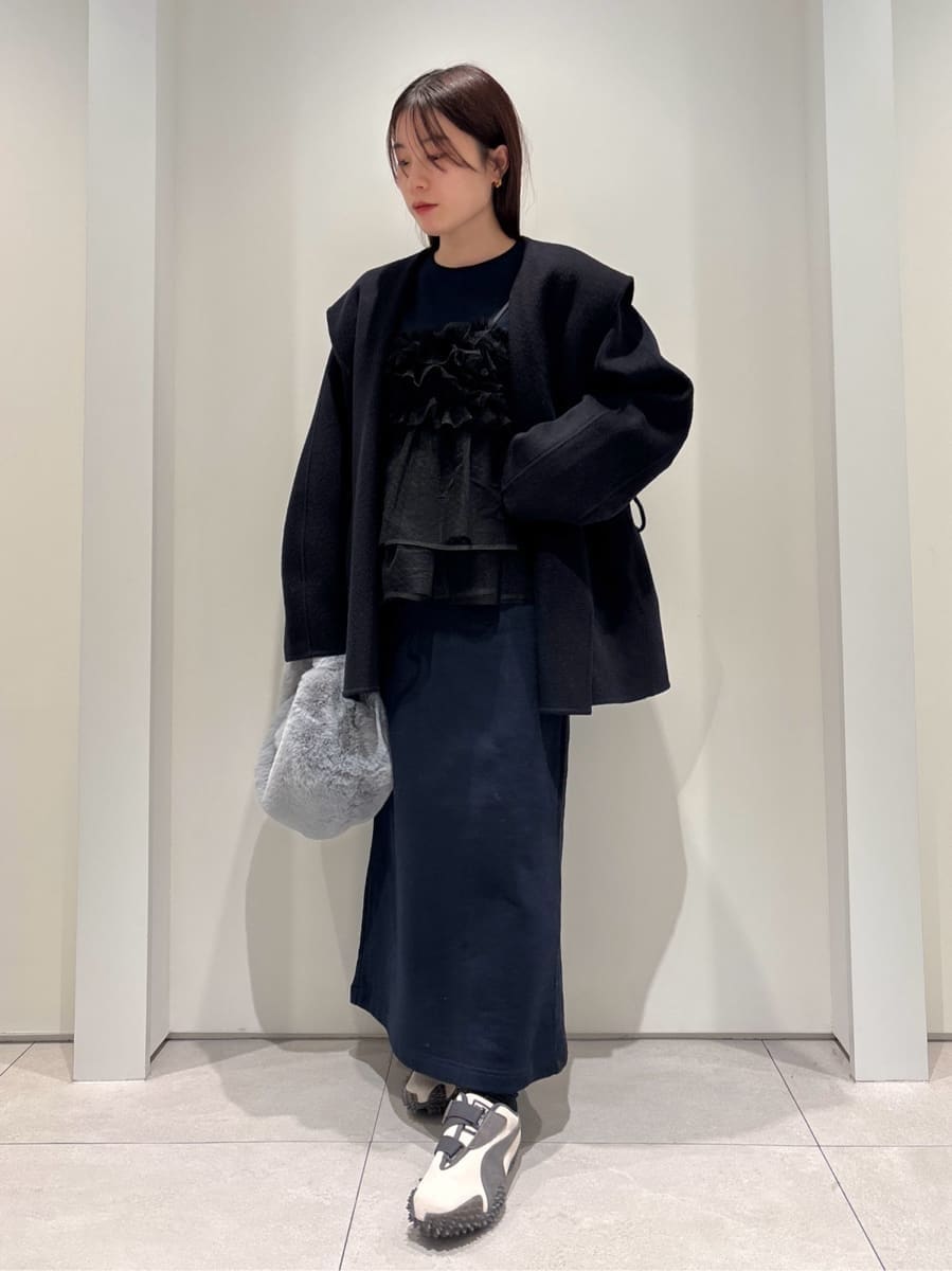 ブルー系のダッフルコート、ブルー系のワンピース、ブルー系のハンドバッグを着用したレディースの冬コーディネートの4枚目の写真