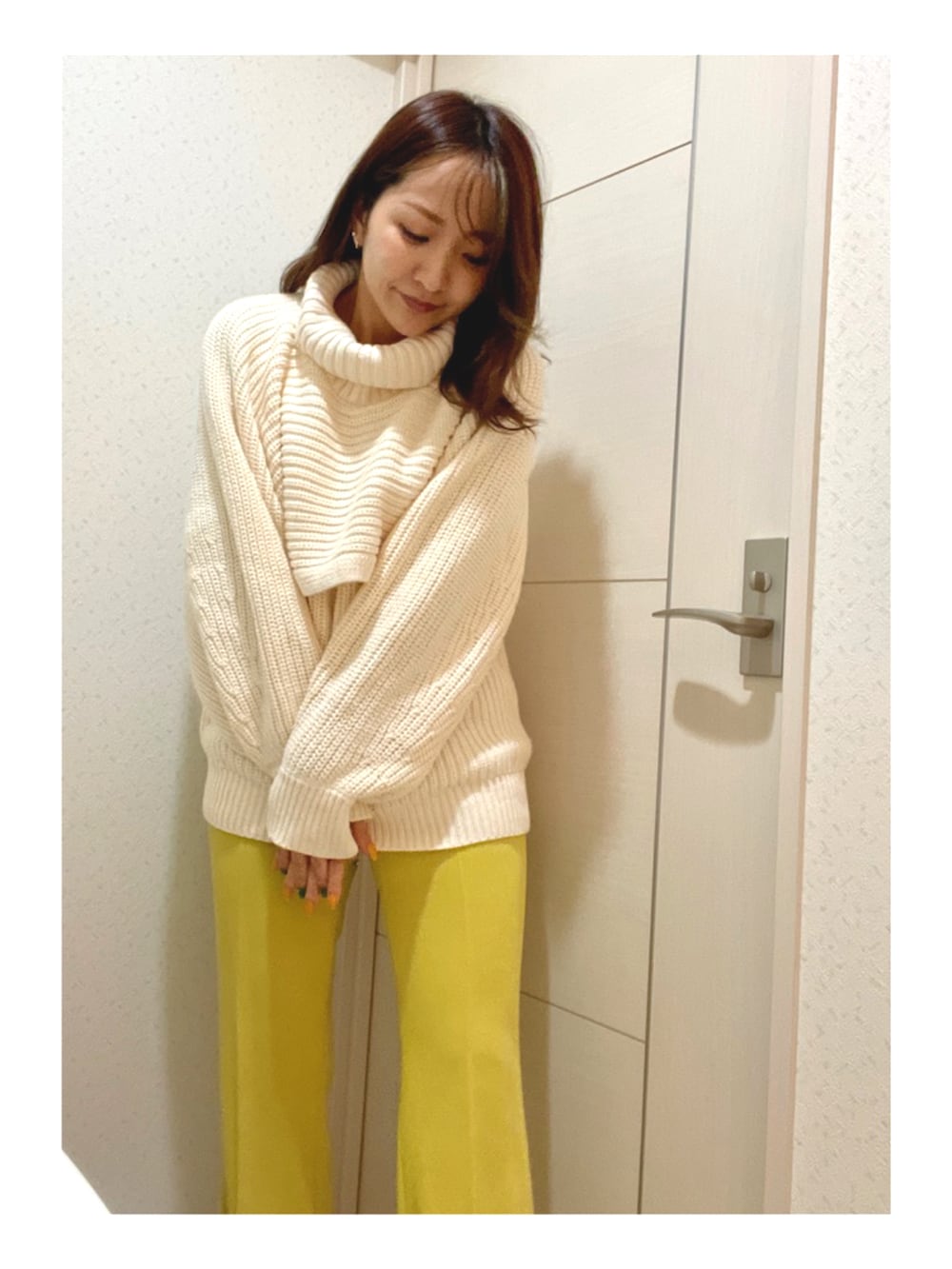 ホワイト系のニット/セーター、イエロー系のパンツ、ブラウン系のトートバッグを着用したレディースの春コーディネートの2枚目の写真